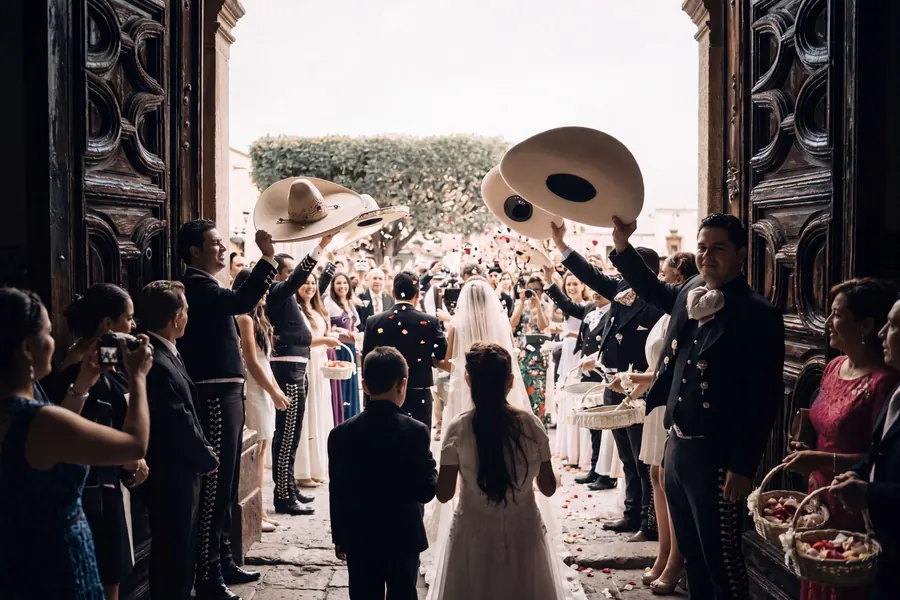 The couple leaving the church under sombreros and a shower of petals, destination wedding