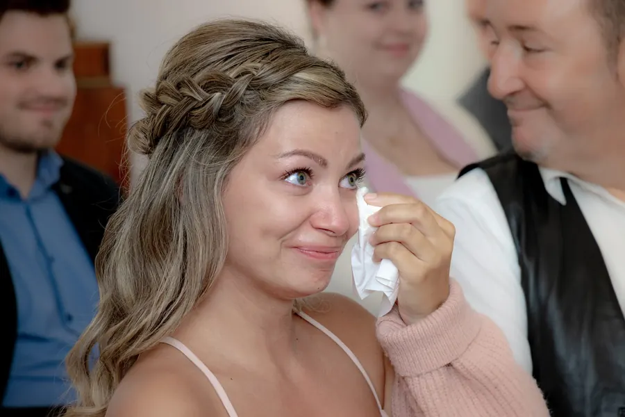 A wedding guest wiping away tears of joy, an emotional moment during the ceremony