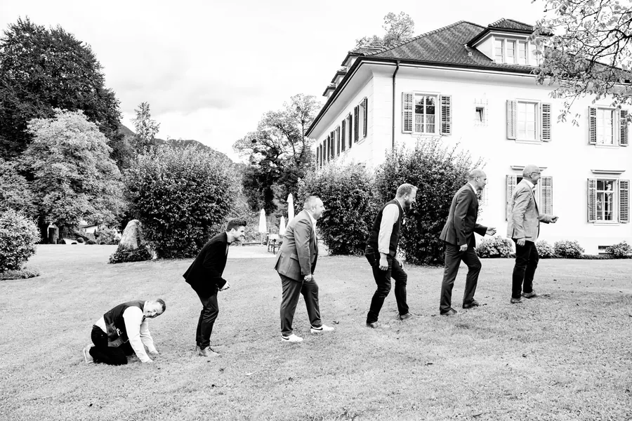 Groom and groomsmen posed as the ascent of man, a wedding photograph with humour