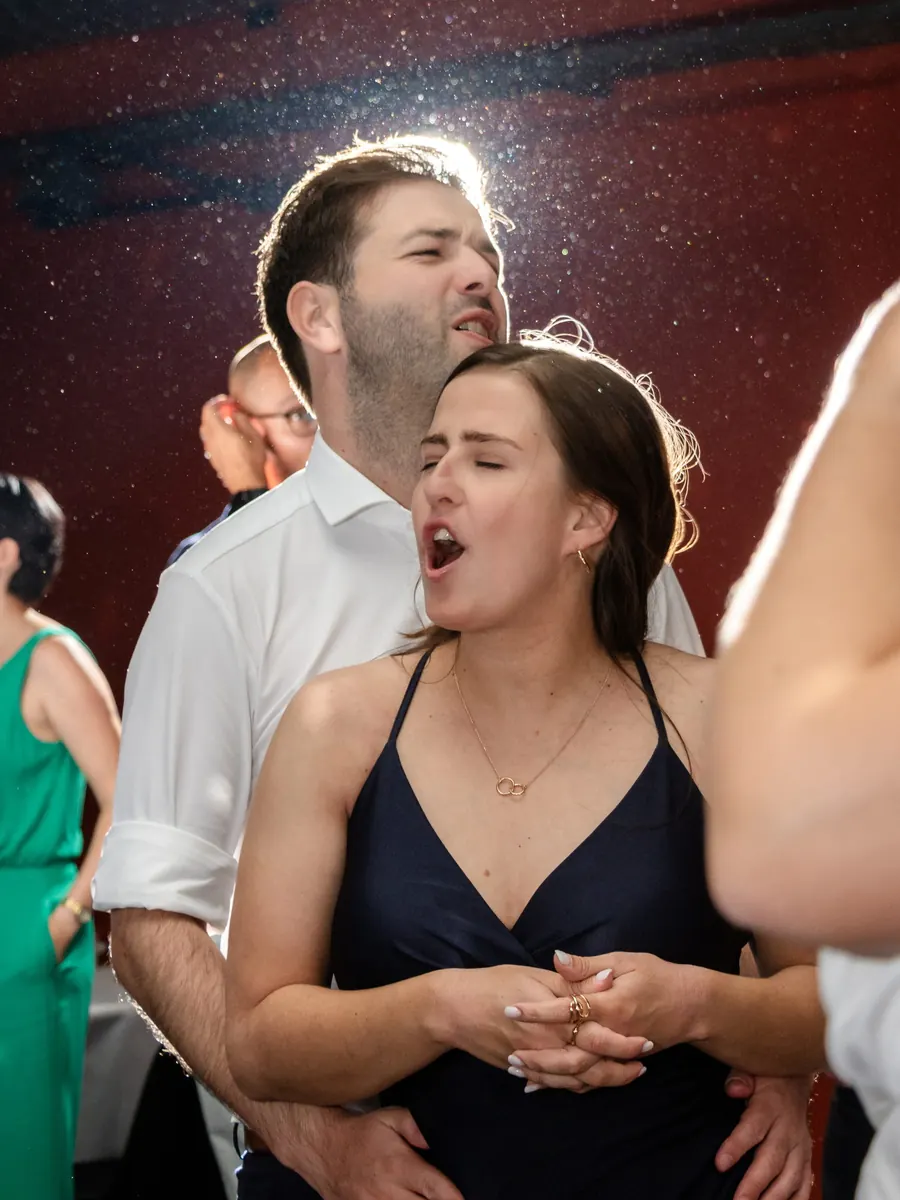Guests singing at full volume on the dance floor, wedding party in a marquee